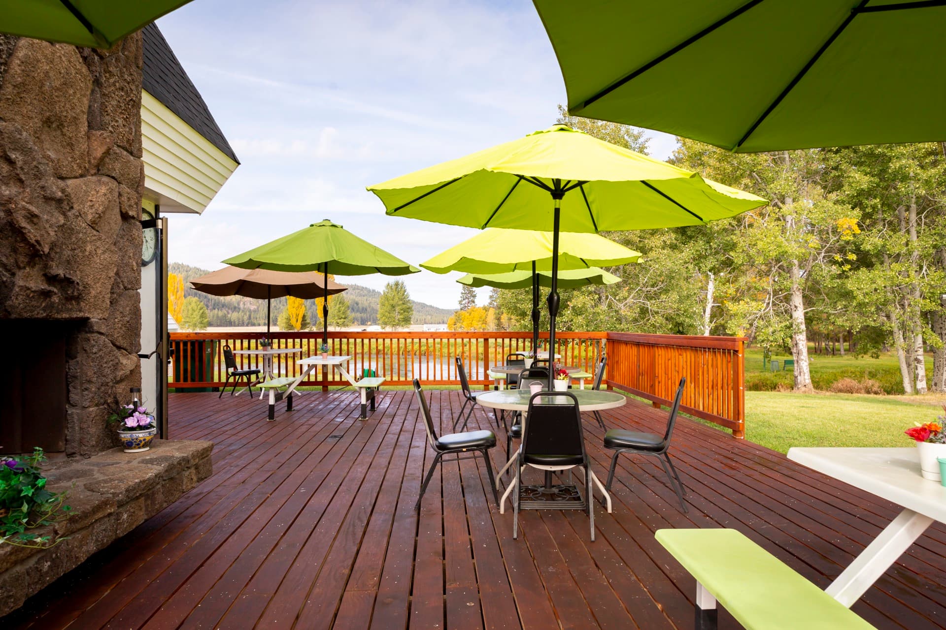Outdoor deck and patio with green umbrellas at Round Lake Community clubhouse